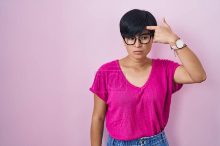 Photo for Young asian woman with short hair standing over pink background pointing unhappy to pimple on forehead, ugly infection of blackhead. acne and skin problem - Royalty Free Image