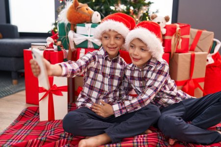 Photo for Adorable boys make selfie by smartphone celebrating christmas at home - Royalty Free Image
