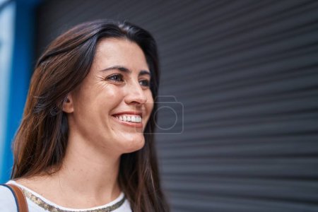 Téléchargez les photos : Young beautiful hispanic woman smiling confident looking to the side at street - en image libre de droit
