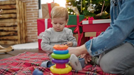 Téléchargez les photos : Père et fils célébrant Noël jouant avec des jouets à la maison - en image libre de droit
