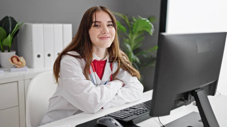 Foto de Joven doctora hispana usando computadora trabajando en clínica - Imagen libre de derechos