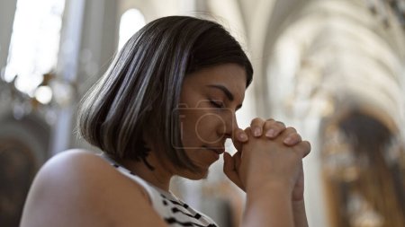 Téléchargez les photos : Jeune belle femme hispanique priant à l'église augustinienne de Vienne - en image libre de droit