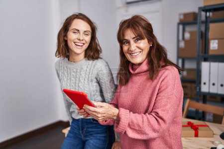 Photo for Two women ecommerce business workers using touchpad working at office - Royalty Free Image