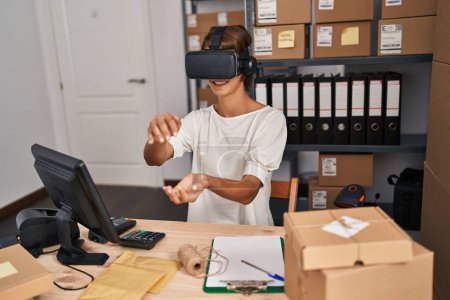 Photo for Young beautiful hispanic woman ecommerce business worker using virtual reality glasses at office - Royalty Free Image