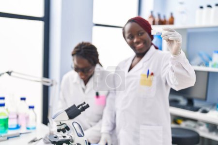 Foto de African american women scientists looking sample writing on document at laboratory - Imagen libre de derechos