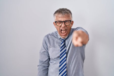 Photo for Hispanic business man with grey hair wearing glasses pointing displeased and frustrated to the camera, angry and furious with you - Royalty Free Image