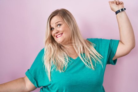 Photo for Caucasian plus size woman standing over pink background dancing happy and cheerful, smiling moving casual and confident listening to music - Royalty Free Image
