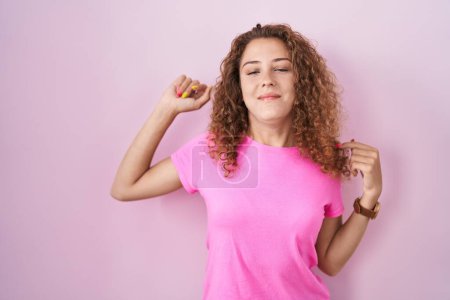 Photo for Young caucasian woman standing over pink background stretching back, tired and relaxed, sleepy and yawning for early morning - Royalty Free Image