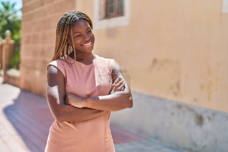 Téléchargez les photos : Femme afro-américaine debout avec les bras croisés geste à la rue - en image libre de droit