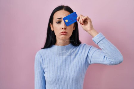 Foto de Mujer hispana con tarjeta de crédito a la vista deprimida y preocupada por la angustia, llorando enojada y asustada. expresión triste. - Imagen libre de derechos