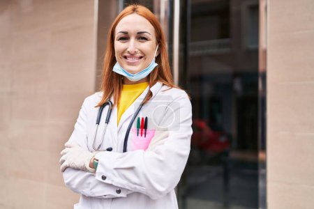 Téléchargez les photos : Jeune femme caucasienne médecin portant un masque médical debout avec les bras croisés geste à l'hôpital - en image libre de droit