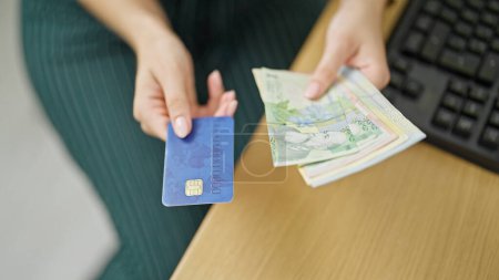 Téléchargez les photos : Jeune femme rousse d'affaires détenant des billets de banque roumains et une carte de crédit au bureau - en image libre de droit