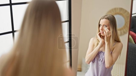 Téléchargez les photos : Jeune femme blonde souriant visage confiant regardant sur le miroir à la rue - en image libre de droit
