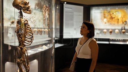 Foto de Joven mujer hispana hermosa visitando exposición antropológica en el Museo de Historia Natural de Viena - Imagen libre de derechos