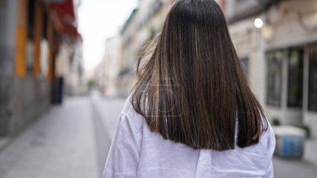 Photo for Young beautiful hispanic woman walking away in the streets of Madrid - Royalty Free Image