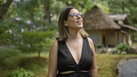 Photo for Stunning photo of a joyful, successful hispanic woman in glasses, radiating happiness while playfully looking around and posing at the classic kodaiji temple in kyoto - Royalty Free Image