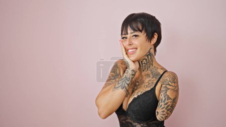 Téléchargez les photos : Femme hispanique avec bras amputé portant lingerie souriant sur fond rose isolé - en image libre de droit