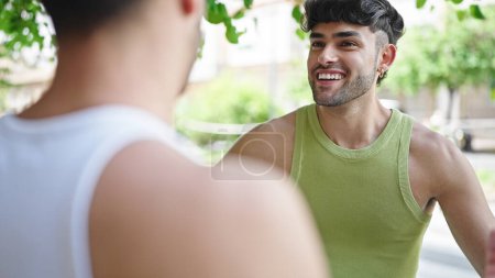 Foto de Dos hombres pareja sonriendo confiado hablando en el parque - Imagen libre de derechos