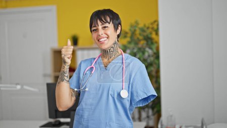 Téléchargez les photos : Femme hispanique avec amputé bras médecin faire pouce vers le haut à la clinique - en image libre de droit