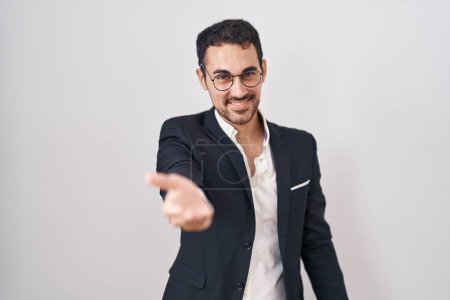Photo for Handsome business hispanic man standing over white background smiling cheerful offering palm hand giving assistance and acceptance. - Royalty Free Image