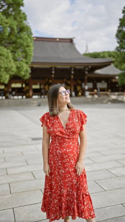 Photo for Cheerful hispanic woman flaunting glasses, exuding joy while nonchalantly posing around tokyo's meiji temple, her beautiful smile spreading positivity and confidence! - Royalty Free Image