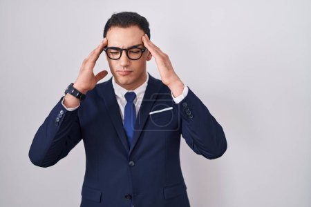 Photo for Young hispanic man wearing suit and tie with hand on head for pain in head because stress. suffering migraine. - Royalty Free Image