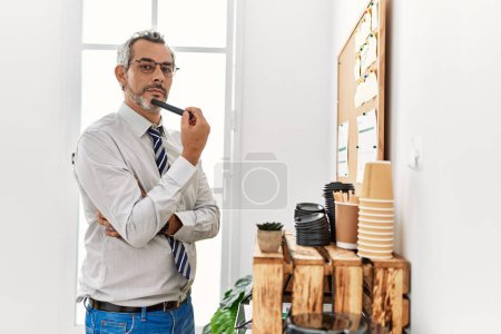 Photo for Middle age grey-haired man business worker reading cork board paper at office - Royalty Free Image