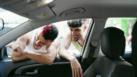 Foto de Dos hombres pareja mirando dentro de un coche nuevo en la calle - Imagen libre de derechos
