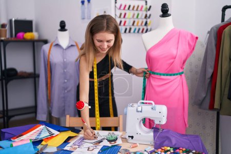 Téléchargez les photos : Jeune femme blonde tailleur mesure robe dessin vêtements design à tailleur boutique - en image libre de droit