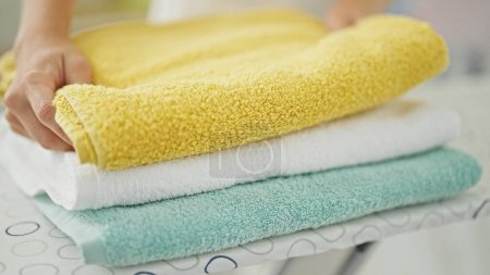 Foto de Joven mujer rubia plegable toallas en la sala de lavandería - Imagen libre de derechos