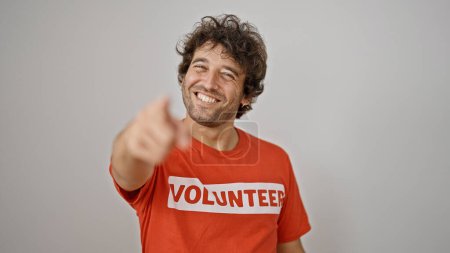 Photo for Young hispanic man activist wearing volunteer uniform pointing to camera over isolated white background - Royalty Free Image