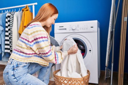 Photo for Young caucasian woman smiling confident washing clothes at laundry room - Royalty Free Image