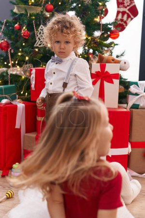 Photo for Adorable boy and girl celebrating christmas at home - Royalty Free Image