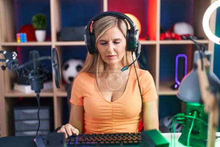 Photo for Young woman playing video games looking sleepy and tired, exhausted for fatigue and hangover, lazy eyes in the morning. - Royalty Free Image