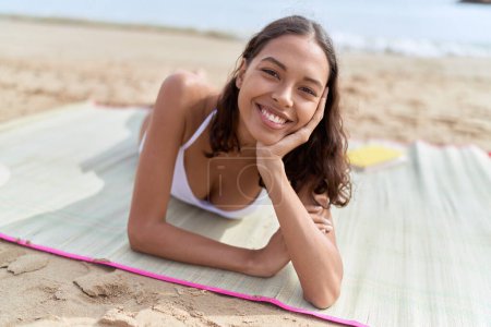 Foto de Joven mujer afroamericana turista con bikini tumbado en la arena en la playa - Imagen libre de derechos