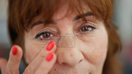 Téléchargez les photos : Femme d'âge moyen souriant confiant toucher maison cercle noir - en image libre de droit