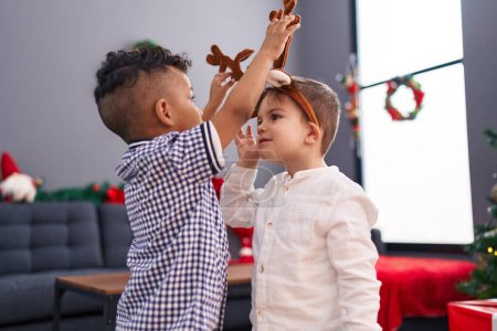 Photo for Adorable boys celebrating christmas wearing reindeer ears at home - Royalty Free Image