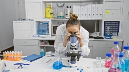 Photo for Young beautiful hispanic woman scientist using microscope at laboratory - Royalty Free Image