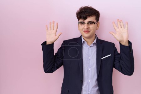 Photo for Young non binary man with beard wearing suit and tie showing and pointing up with fingers number ten while smiling confident and happy. - Royalty Free Image