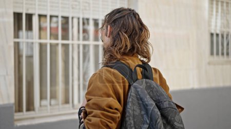 Foto de Joven turista hispano con mochila de pie en la calle - Imagen libre de derechos