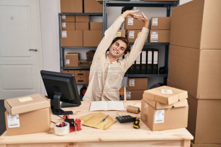 Téléchargez les photos : Young caucasian man ecommerce business worker stretching arms at office - en image libre de droit