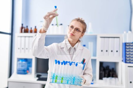 Téléchargez les photos : Jeune femme blonde scientifique tenant des éprouvettes au laboratoire - en image libre de droit