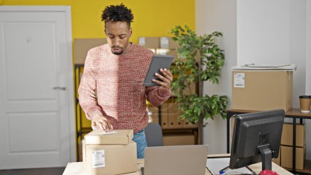 Foto de Hombre afroamericano comercio electrónico trabajador de negocios utilizando touchpad en la oficina - Imagen libre de derechos