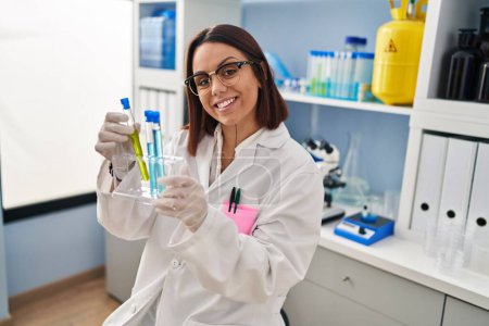 Photo for Young beautiful hispanic woman scientist smiling confident holding test tubes at laboratory - Royalty Free Image