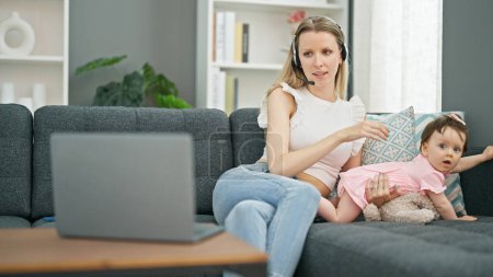 Photo for Mother and daughter working while care baby at home - Royalty Free Image