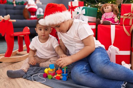 Photo for Adorable boys celebrating christmas playing with toy at home - Royalty Free Image
