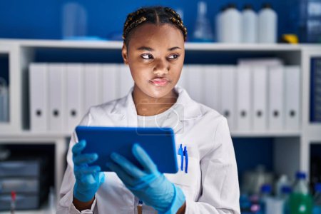Photo for African american woman scientist using touchpad at laboratory - Royalty Free Image