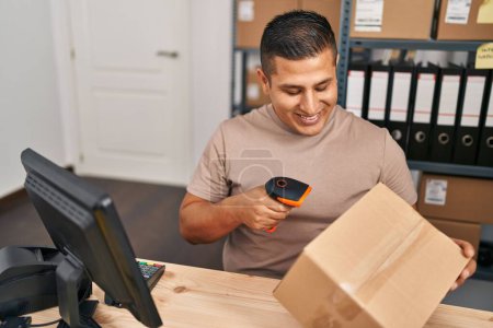 Téléchargez les photos : Young latin man ecommerce business worker scanning package at office - en image libre de droit