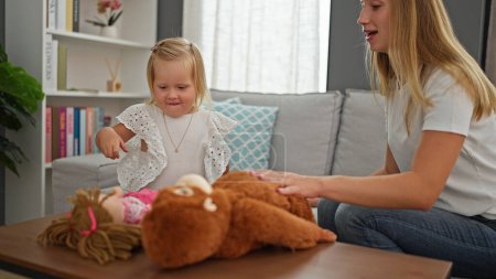 Photo for Happy caucasian mother and little daughter comfortably enjoying and playing with toys at home, resting on the sofa - Royalty Free Image