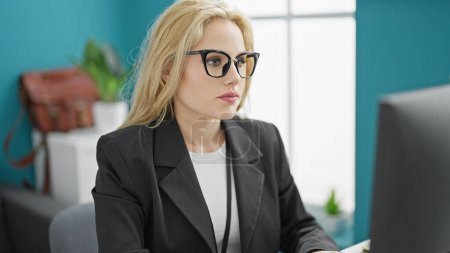 Téléchargez les photos : Jeune femme blonde travailleuse d'affaires utilisant la pensée informatique au bureau - en image libre de droit